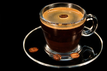 Coffee glass cup and coffee beans on saucer
