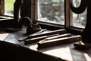 Old vintage blacksmith tools in the old smithy on the windowsill