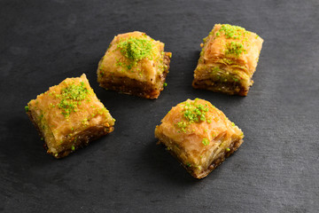 Pistachio baklava on a black plate. Dessert.