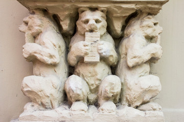 Statue of three bears on building's facade in the center of Vilnius, Lithuania, old town of Vilnius. Art. White. Sculpture of three bears.