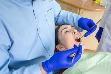 Young woman sits in a dental chair as a patient. People health care, dentistry, medicine concept. Doctor and patient. Teeth dentist with patient in hospital