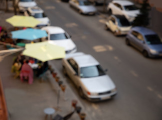 Blurred image of city street, cafe, house and car photo for background with place for text. View from above.