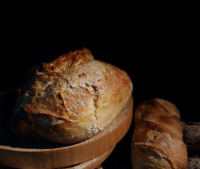 Freshly baked bread on a table against a dark background.