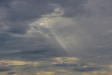 Obraz premium The sun's rays at sunset making their way through the clouds.