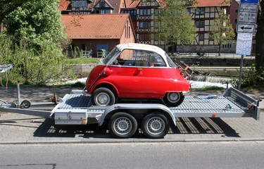 PKW-Anhänger beladen mit einem roten Oldtimer