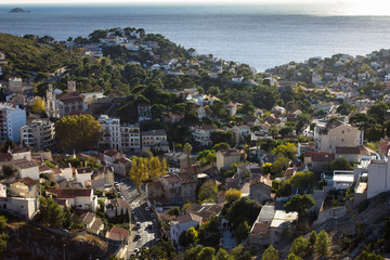 Cityscape and seascape of mediterranean sea from the top of the hill of Notre Dam de la Garde cathedral in Marseilles, Provence, France. Sunny port, harbour, brown tile roof tops.