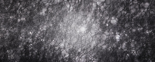 Black-white texture of soap suds in macro with ordered structures and cavities