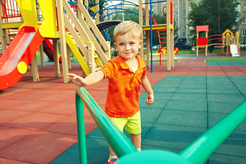 little boy on playground. child playing with carousel