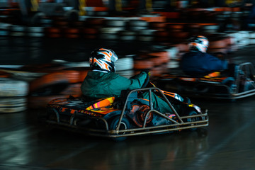 Dynamic karting competition at speed with blurry motion on an equipped racecourse - obrazy, fototapety, plakaty