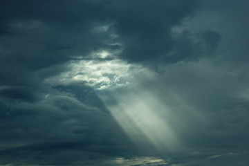 The sun's rays at sunset making their way through the clouds.