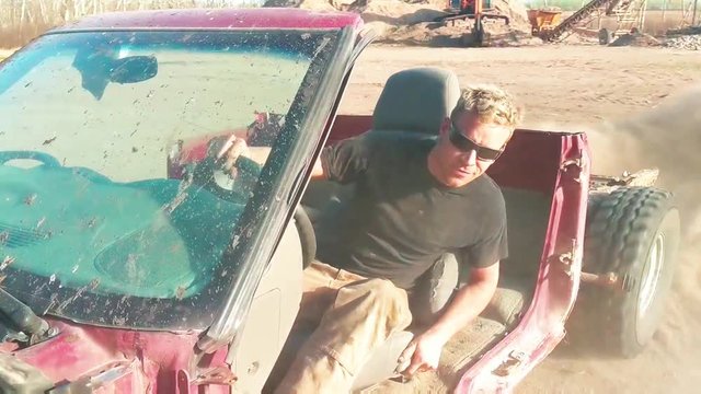 A redneck does a burn out and some donuts in a dusty field.