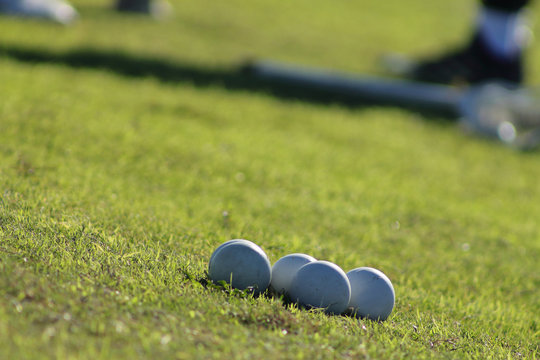Close up picture of lacrosse balls on the green field.
