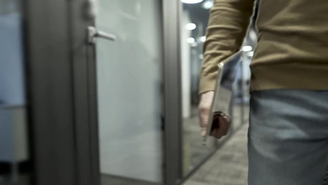 In This Shot Camera Follows Business Man Walking Around The Office Space With Tablet Device In His Hand.