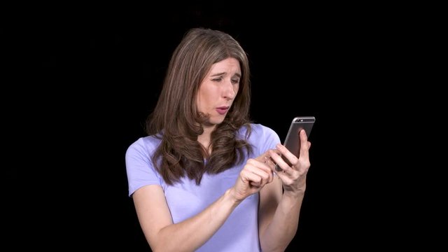 Caucasian brunette woman browsing cute photos on her smart phone while standing on a black background