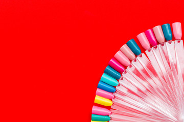 work desk at nail bar with palette of nail polish for manicure on red background top view mockup