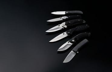 folding knives on a black background. pen knives on a dark background