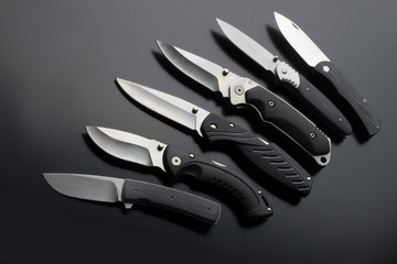 folding knives on a black background. pen knives on a dark background