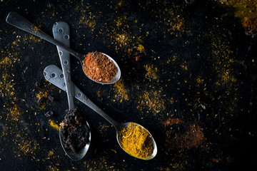 Fototapeta na wymiar Various colorful spices on black background, top view.