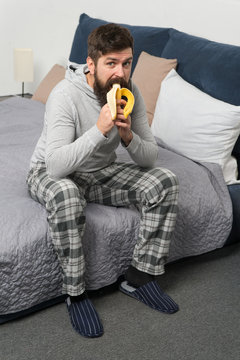 Morning Vibes At Home. Bearded Man Hipster Eat Banana In Morning. Brutal Sleepy Man Has Breakfast In Bedroom. Mature Male With Beard In Pajama On Bed. Sleep And Awake. Healthy Lifestyle. Sweet Home