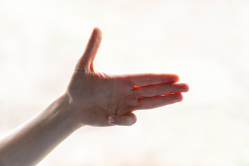 Hand of woman in gun gesture isolated on blurred background