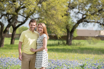 Young Millennial Couple Standing During Spring in a Field of Blue Bonnets