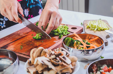 Female hands chopping broccoli, preparing ingredients for a delicious meal