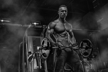 Fototapeta premium Attractive tall muscular bodybuilder doing heavy deadlifts in moder fitness center.