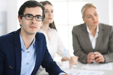 Fototapeta premium Group of business people discussing questions at meeting in modern office. Managers at negotiation or brainstorm. Teamwork, partnership and business concept