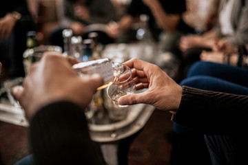 A close up shot of a man pouring whisky from a samlping bottle. Concept of fine alcohol, tasting of Japanese whisky. Master class and degustation. - obrazy, fototapety, plakaty