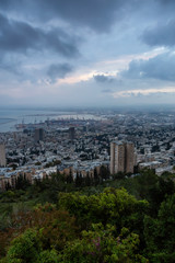 Fototapeta na wymiar Beautiful view of a city on the coast of Mediterranean Sea during a cloudy sunset. Taken in Haifa, Israel.