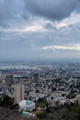 Obraz premium Beautiful view of a city on the coast of Mediterranean Sea during a cloudy sunset. Taken in Haifa, Israel.