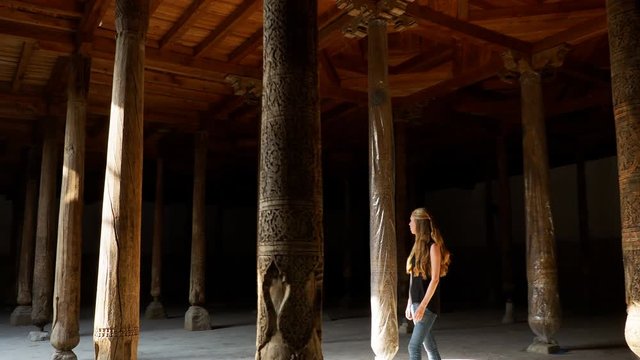 Young woman walking through rustic temple