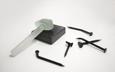 Glass Hammer and crooked glass nails on white background
