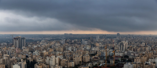 Aerial view of a residential neighborhood in a city during a cloudy sunrise. Taken in Netanya, Center District, Israel.