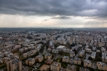 Aerial view of a residential neighborhood in a city during a cloudy sunrise. Taken in Netanya, Center District, Israel.