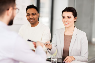 new job, hiring and employment concept - international team of recruiters having interview with male employee at office