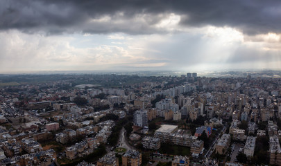 Obraz premium Aerial view of a residential neighborhood in a city during a cloudy sunrise. Taken in Netanya, Center District, Israel.
