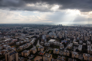 Obraz premium Aerial view of a residential neighborhood in a city during a cloudy sunrise. Taken in Netanya, Center District, Israel.