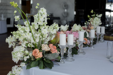 newlyweds table in restaurant decoration fresh flowers and candles. Wedding fresh flowers decoration