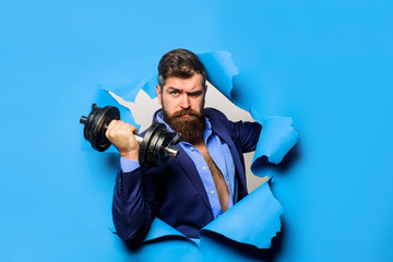 Through paper. Bearded man with dumbbell. Sport. Bearded man through paper. Workout. Fitness. Healthy lifestyle. Discount. Season sales. Copy space for advertising.