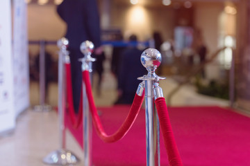 Silver stanchions with a red rope. Barrier, enclosed VIP area, protected enterance, private event, luxury gala concept.