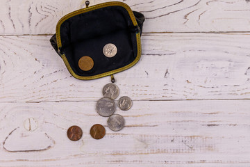 Old change purse with several coins on white wooden background. Concept of poverty or bankruptcy