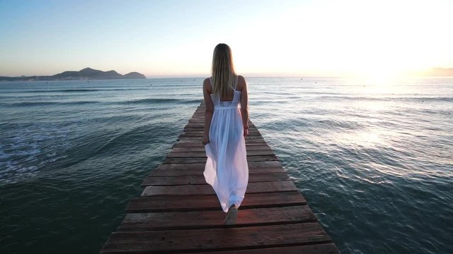 Girl walks down the bridgte to the Sea of Mallorca