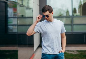 A stylish man in a gray  T-shirt. Street photo