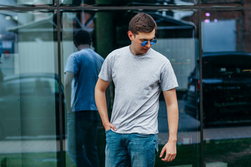 A stylish man in a gray  T-shirt. Street photo