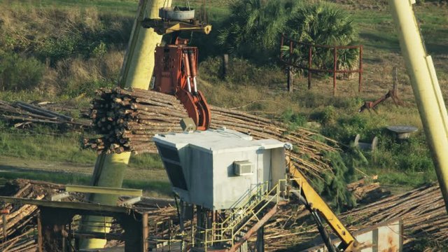 Aerial view crane moving timber for processing USA