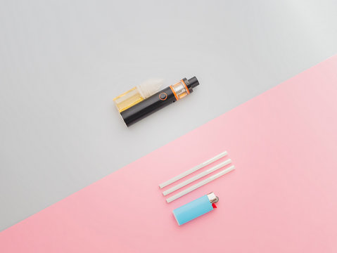 Popular vape device with liquid. No smoking. Change habit of smoking. Concept for more healthy life. Difference between cigaretts and vape. Flat lay with bad habits on blue and pink backdrop