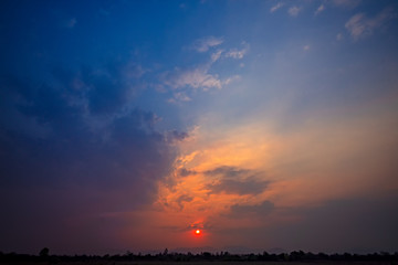Natural Sunset Sunrise Over Field Or Meadow. Bright Dramatic Sky And Dark Ground. Countryside Landscape Under Scenic Colorful Sky