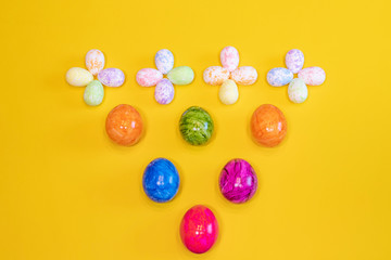 Fototapeta na wymiar A lot of colorful Easter eggs on a yellow background. Top view, minimal Easter concept. Happy Easter card with free, empty space.