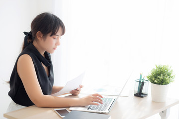 Beautiful young asian woman working and typing laptop computer at office, businesswoman looking graph diagram analysis statistic data of finance, girl using notebook, profit growth, business concept.